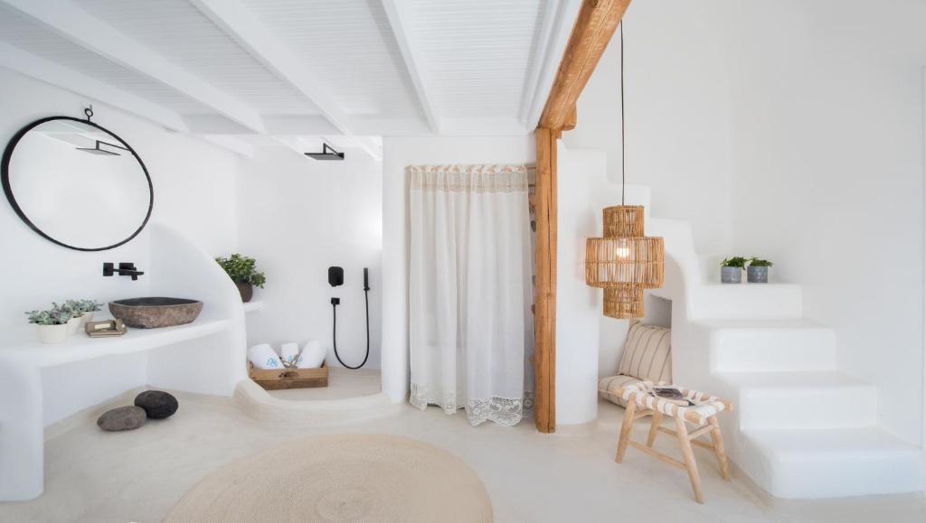 een witte badkamer met een douche en een spiegel bij Sophia Boutique Hotel in Oia