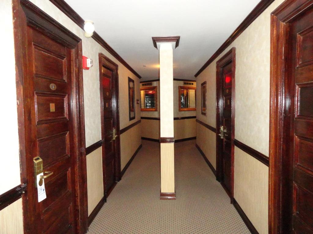 
a hallway with a door leading to a room with a large mirror at Hotel 31 Extended Stay in New York
