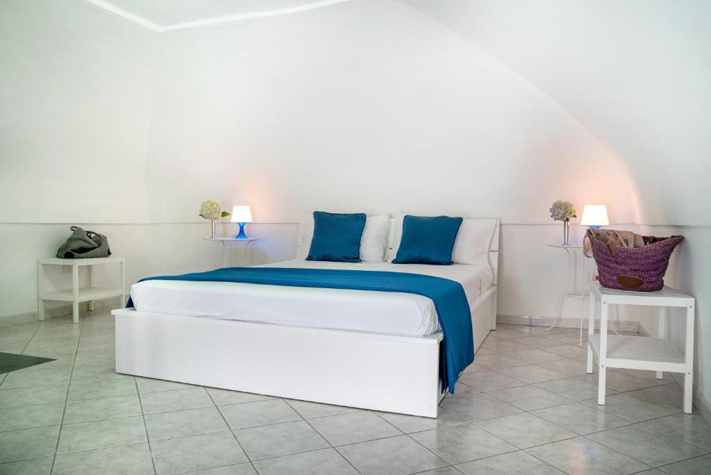 1 cama blanca con almohadas azules en una habitación en Accasarte, en Procida