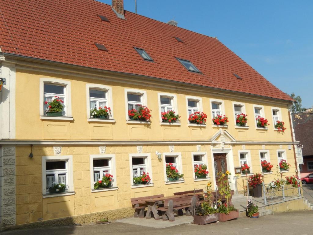 um edifício amarelo com caixas de flores nas janelas em Gasthof Goldenes Rössle em Dinkelsbühl