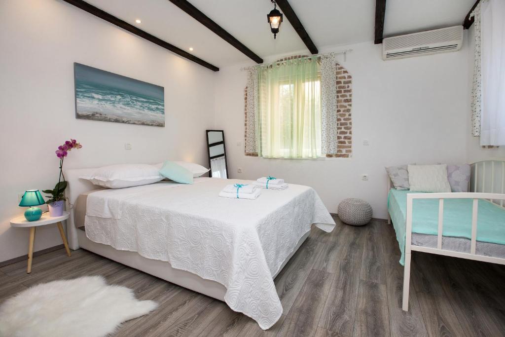 - une chambre avec un lit blanc et une table dans l'établissement Apartment Barka, à Split