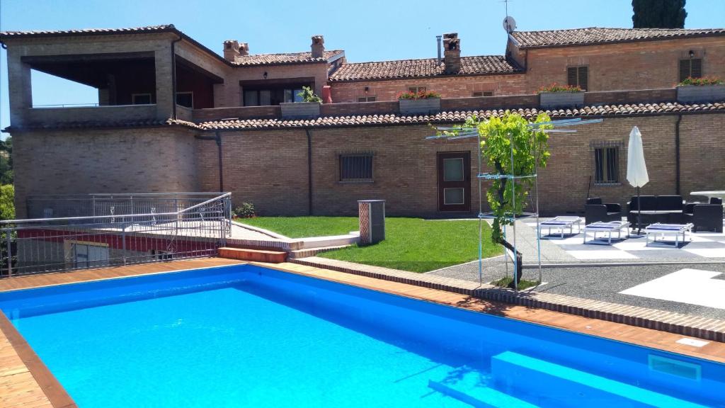 una villa con piscina di fronte a una casa di Mulino del Mare a Saludecio