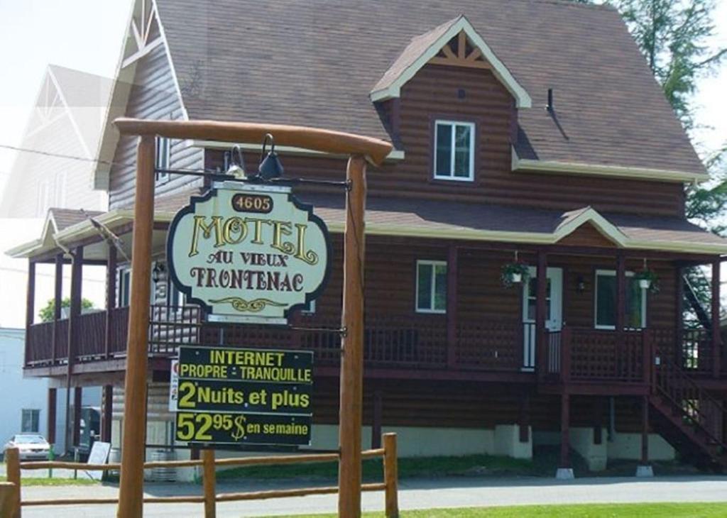 una casa de madera con un cartel delante en Motel Au Vieux Frontenac, en Thetford Mines