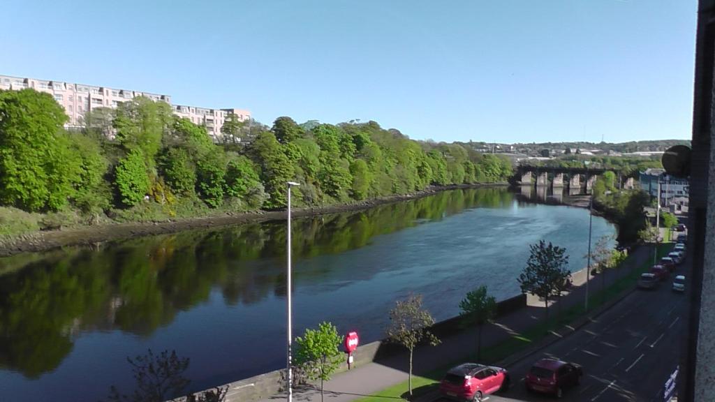 une rivière avec des voitures garées sur son côté dans l'établissement Mycosy on the river, à Aberdeen