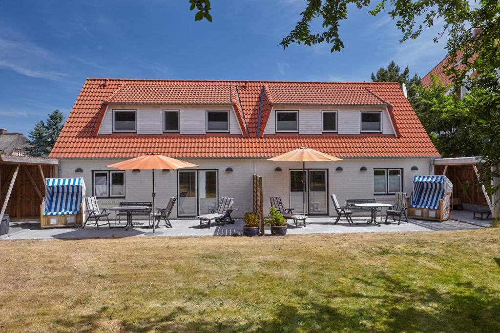 a house with chairs and tables in front of it at "Strand" - Haus Hartwig in Sankt Peter-Ording