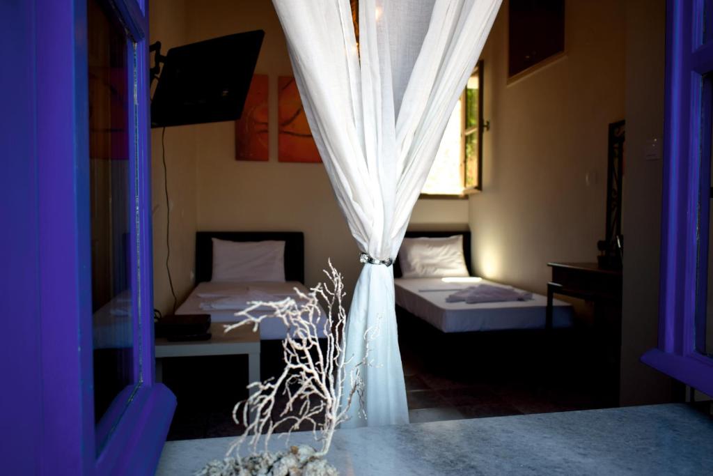 een kamer met 2 bedden en een raam bij Occasus Room in Halki
