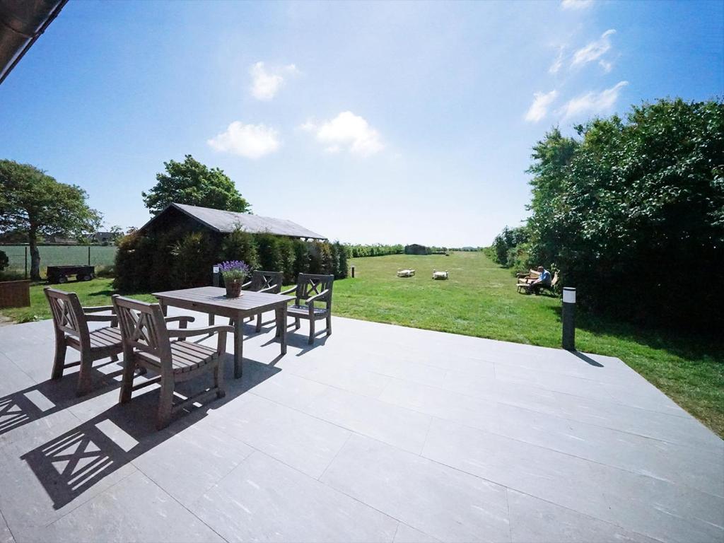 a patio with a table and chairs and a field at Terpstich 60A in Morsum