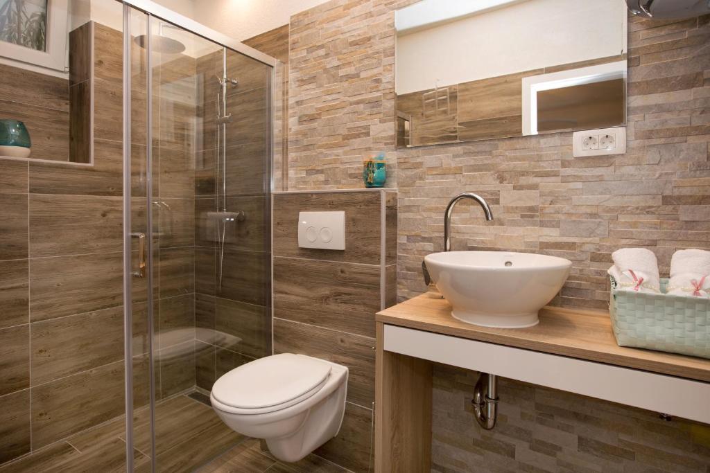 une salle de bain avec une douche, des toilettes et un lavabo dans l'établissement Apartment Barka, à Split