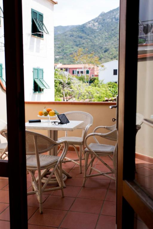 a table and chairs on a balcony with a view at Hotel Corallo in Pomonte