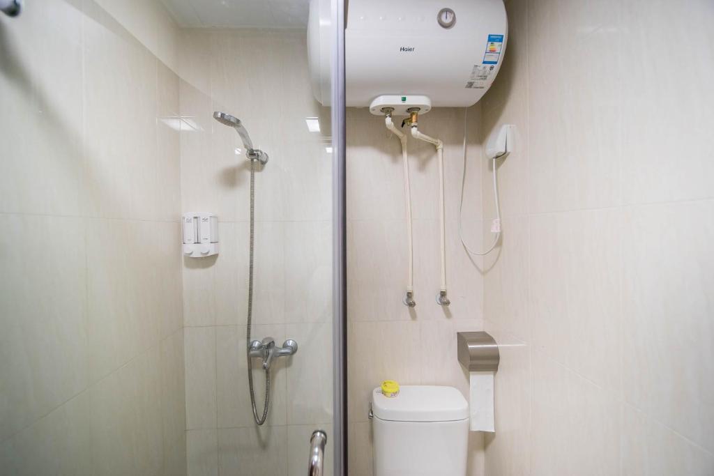 a small bathroom with a shower and a toilet at Xing Yu Legend Service Apartment Canton Fair Branch in Guangzhou