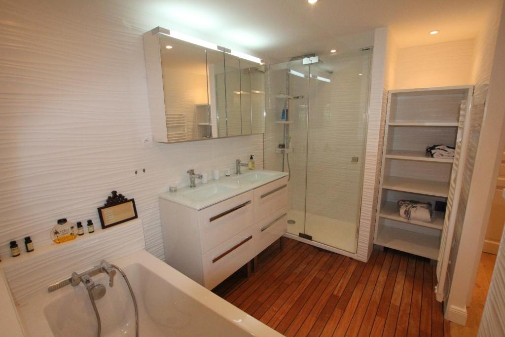ein Bad mit einer Badewanne, einem Waschbecken und einer Dusche in der Unterkunft La Cabane du Bois in Arcachon
