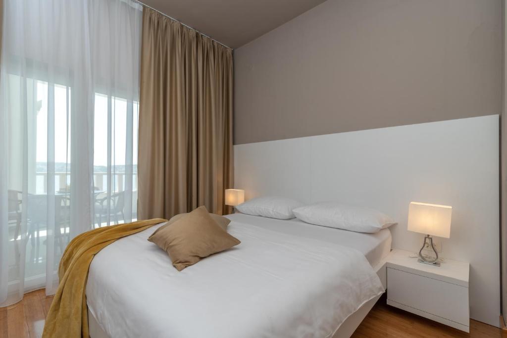 una camera con un letto bianco e una grande finestra di Villa Ana Trogir a Trogir