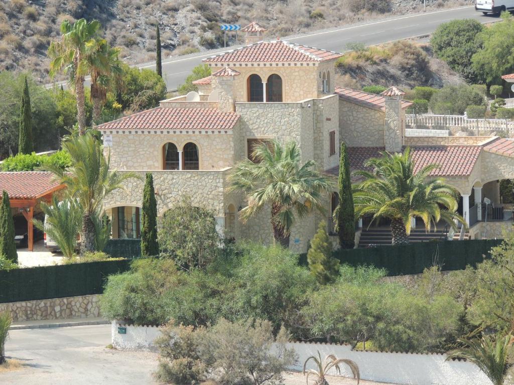 uma casa grande com palmeiras em frente a uma estrada em Calapanizo "Un paraíso" em El Pozo del Esparto