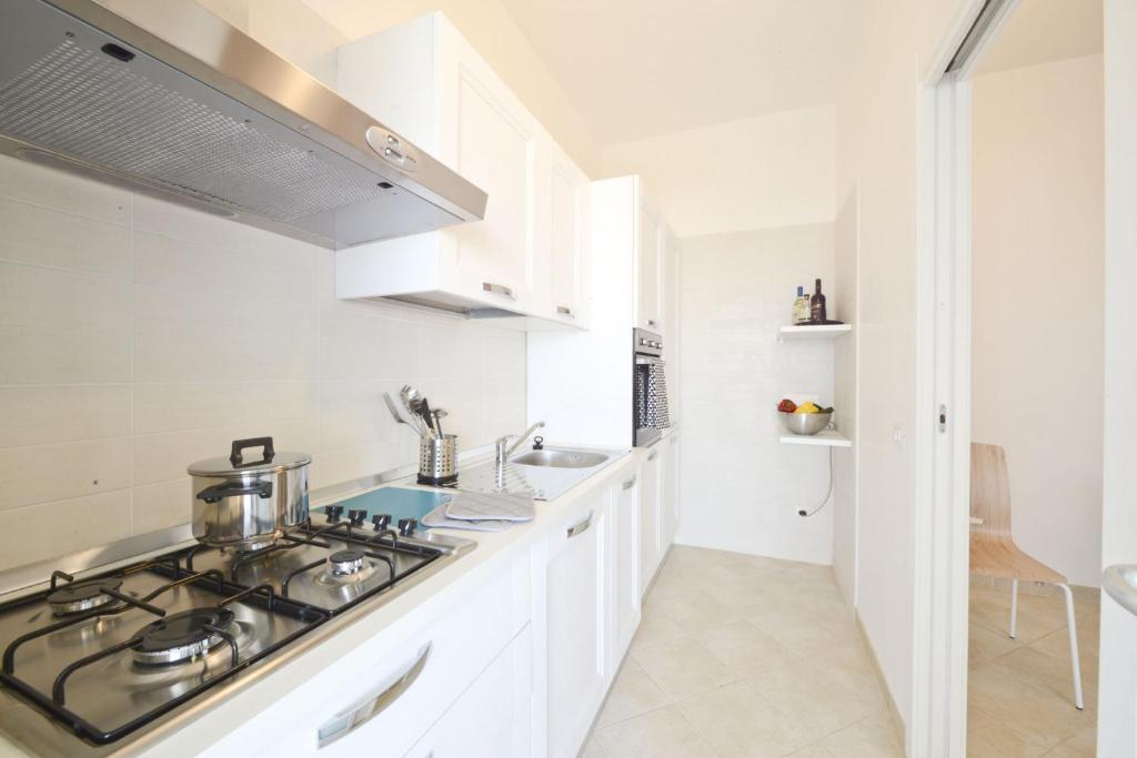 a white kitchen with a stove and a sink at Blue Sea Villas by Wonderful Italy in Ostuni