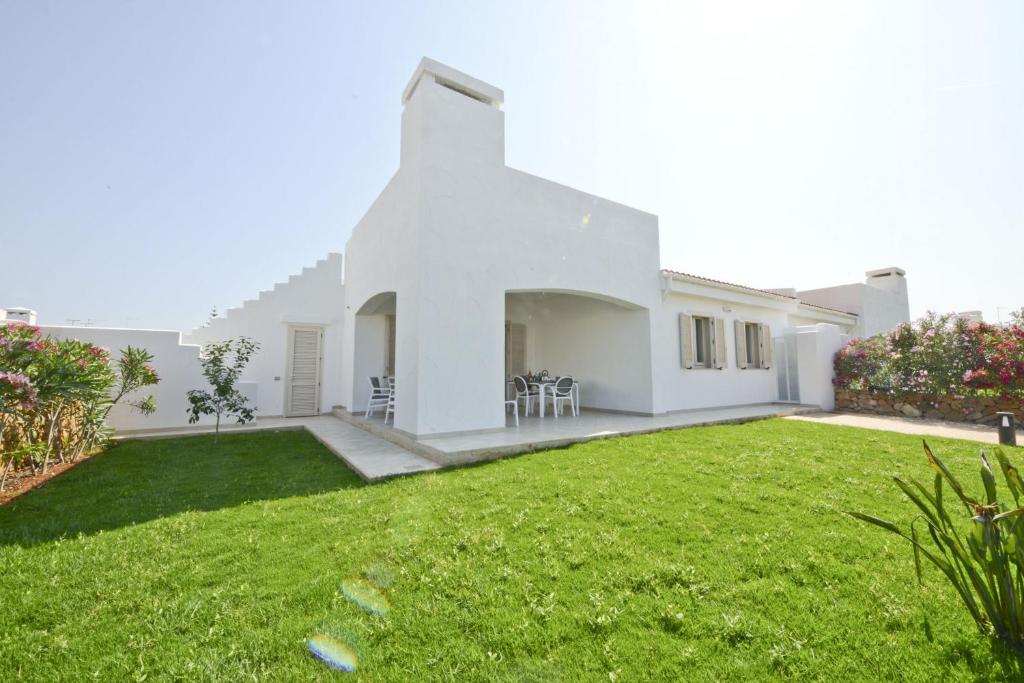 a white house with a green yard at Blue Sea Villas by Wonderful Italy in Ostuni