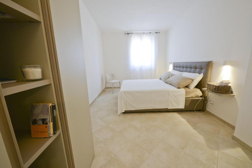 a small bedroom with a bed and a window at Blue Sea Villas by Wonderful Italy in Ostuni