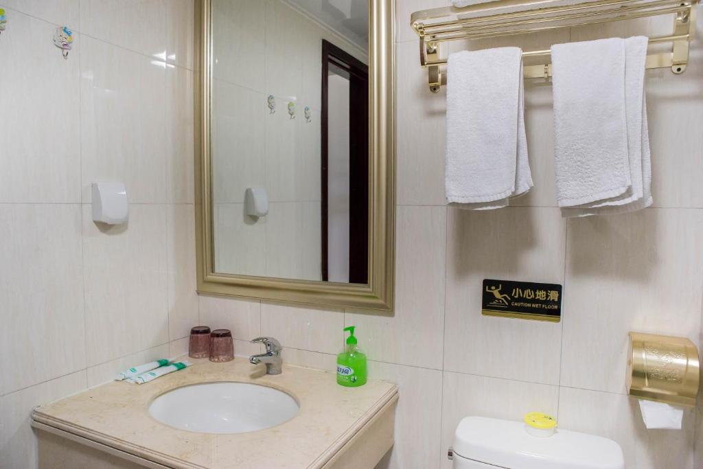 a bathroom with a sink and a mirror and a toilet at Xing Yu Legend Service Apartment Canton Fair Branch in Guangzhou