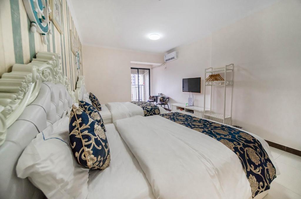 a bedroom with a large white bed and a television at Xing Yu Legend Service Apartment Canton Fair Branch in Guangzhou