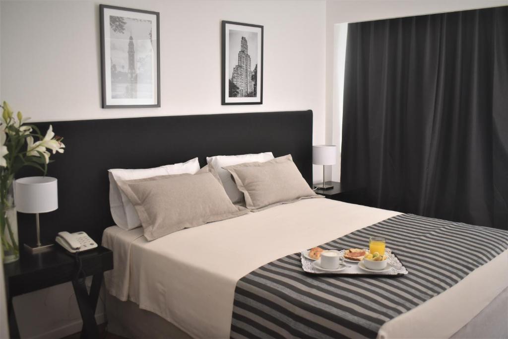 a bedroom with a bed with two plates of food on it at Grand King Hotel in Buenos Aires