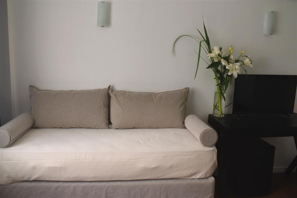 a living room with a couch with a vase of flowers at Grand King Hotel in Buenos Aires