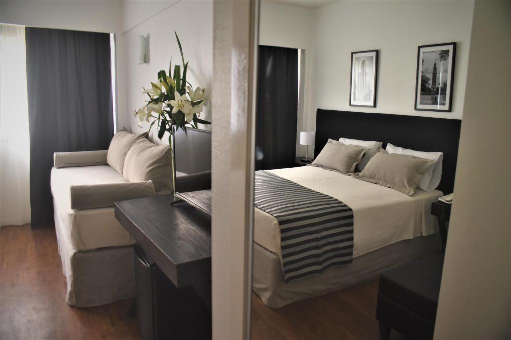 a hotel room with a bed and a couch at Grand King Hotel in Buenos Aires