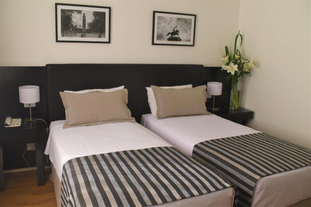 two beds sitting next to each other in a bedroom at Grand King Hotel in Buenos Aires