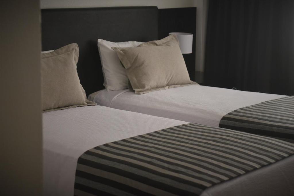 two beds in a hotel room with pillows at Grand King Hotel in Buenos Aires