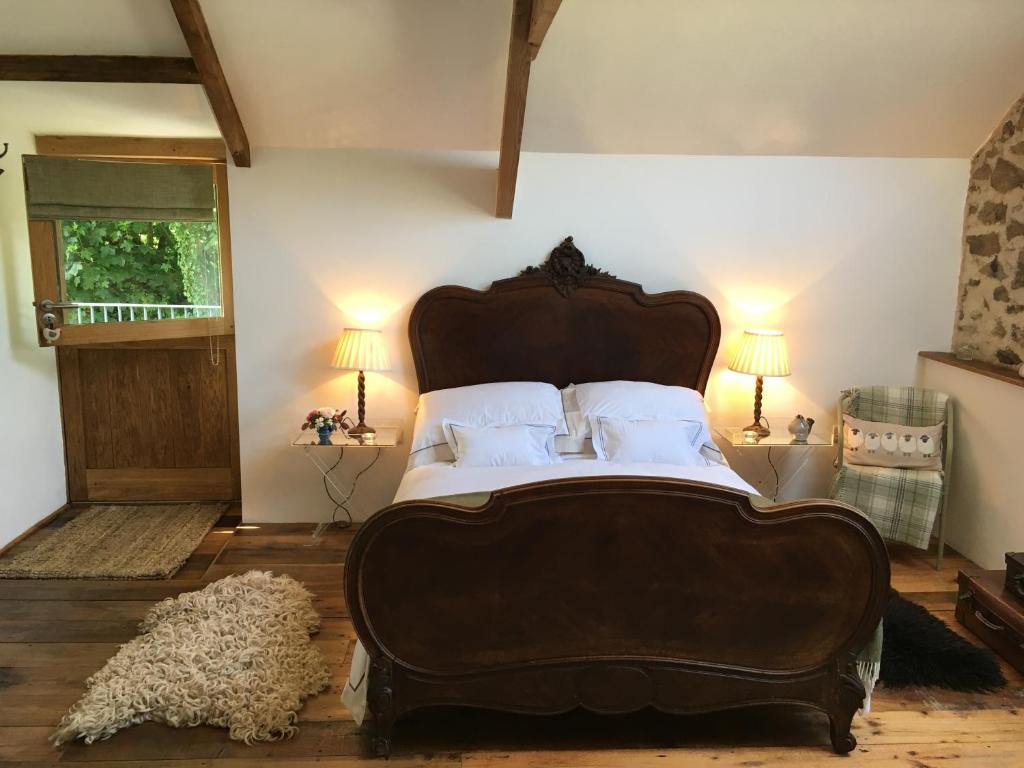 a bedroom with a large bed and a dog laying on the floor at The Granary in Lifton