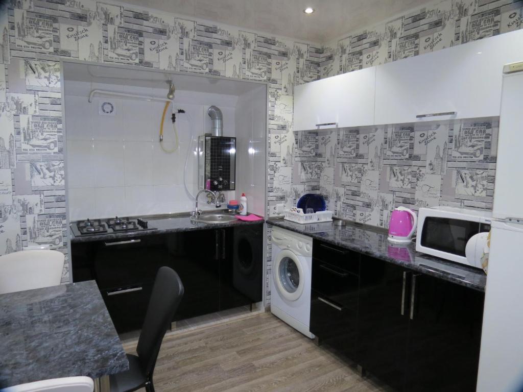 a kitchen with a sink and a washing machine at Apartment Tamara On Khandzteli Street in Tbilisi City