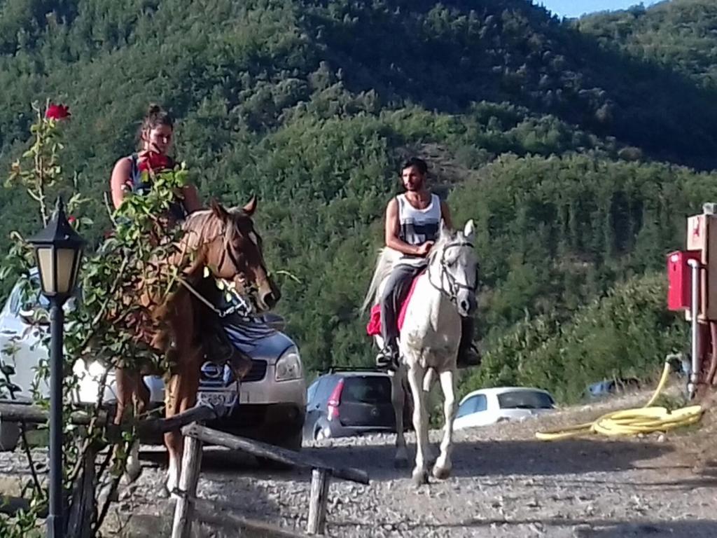 dos personas montando a caballo en una carretera en Le Chianine dei Tognoli, en Gragnola