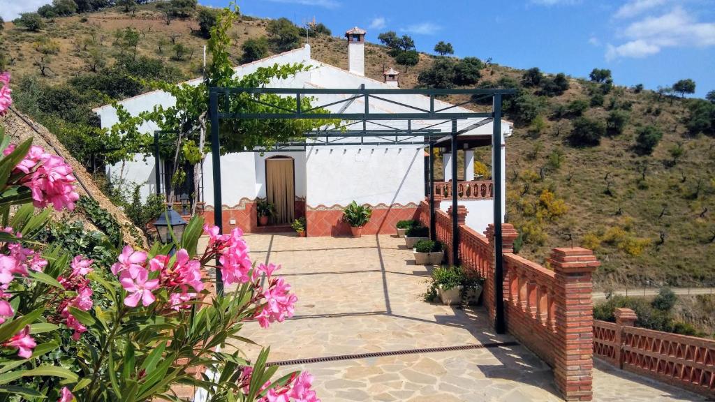 アロラにあるCasa Encina - Encinasola Turismo Rural.の白い塀とピンクの花の建物