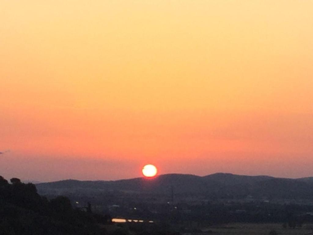 um pôr-do-sol com o pôr-do-sol sobre as montanhas em Residenza la Gioiosa. em Scarlino