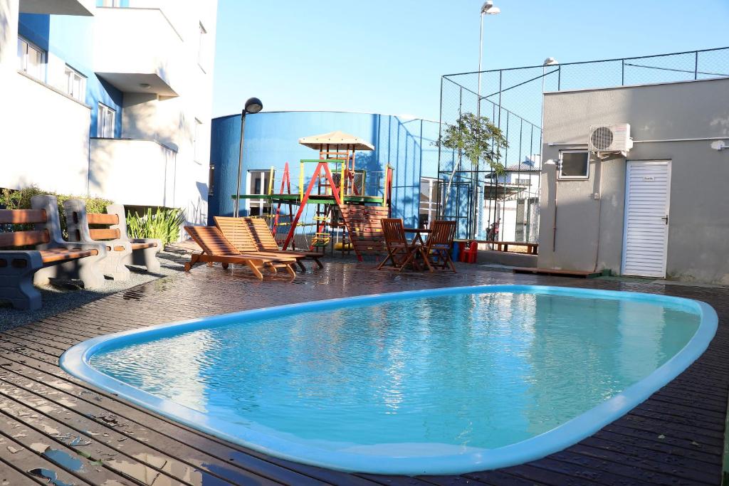 a swimming pool on the roof of a building with a playground at Curta Praia do Quilombo - Lunata in Penha