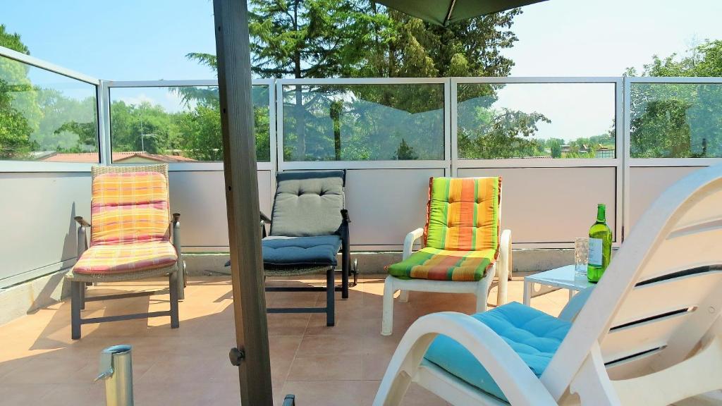 dwa krzesła i stół na balkonie z oknami w obiekcie Apartments Rukavina w mieście Umag