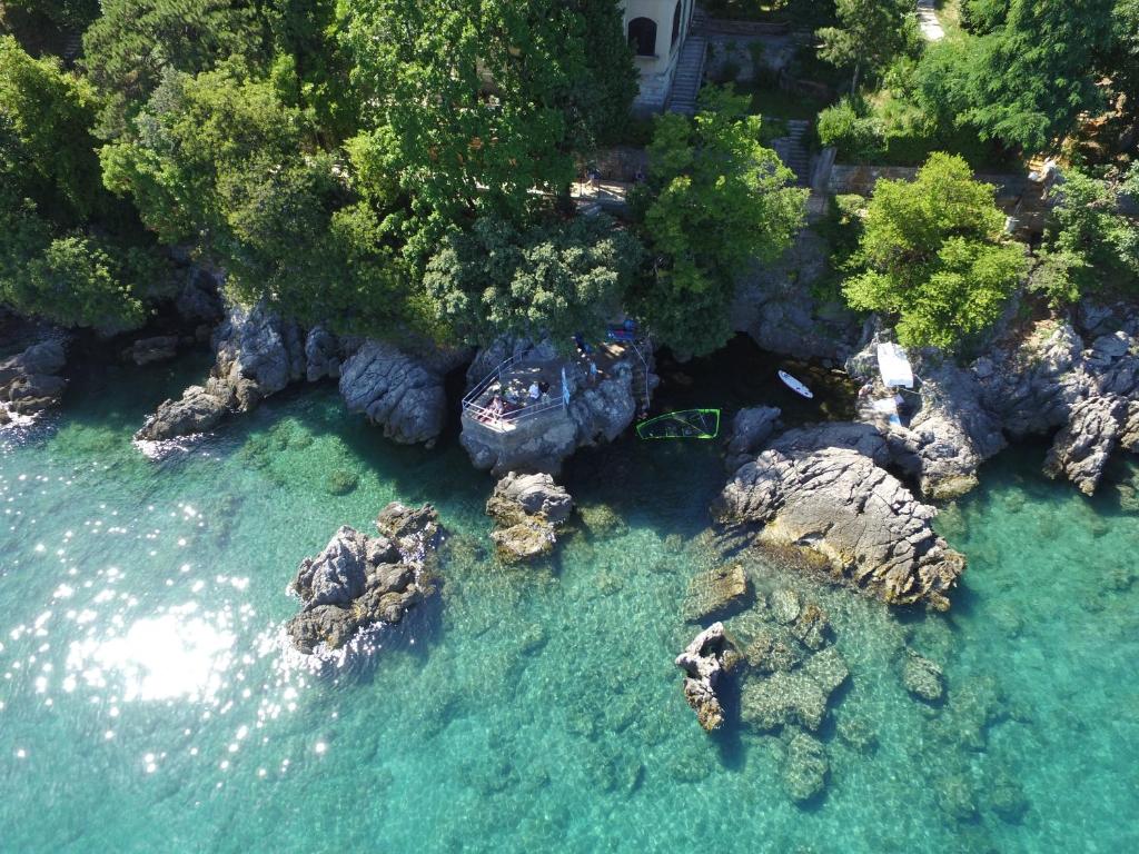 z góry widok na plażę z kamieniami i wodą w obiekcie Premium Apartments Punta Kolova w mieście Opatija