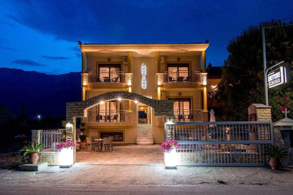 Una casa grande con un arco delante de ella por la noche. en Emotions, en Skala Potamias