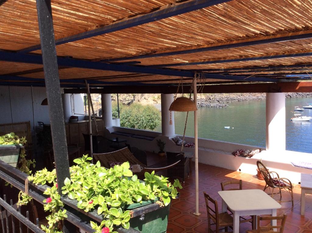 eine Terrasse mit Pflanzen und einem Tisch und Blick auf das Wasser in der Unterkunft Albergo Seaside in Leni