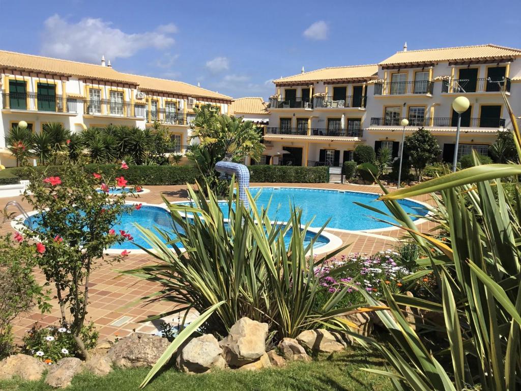 a resort with a swimming pool and some buildings at Casa Deolinda Street of Sea and Golf in Guia