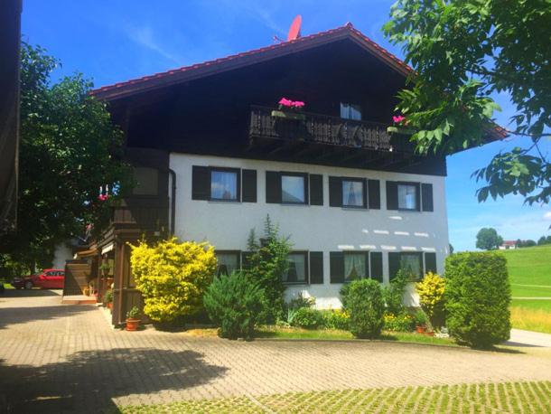 uma casa grande com uma varanda em cima em Gästehaus Grieser em Hopferau