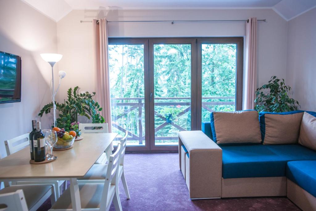 a living room with a blue couch and a table at Apartamenty Niegocin in Wilkasy