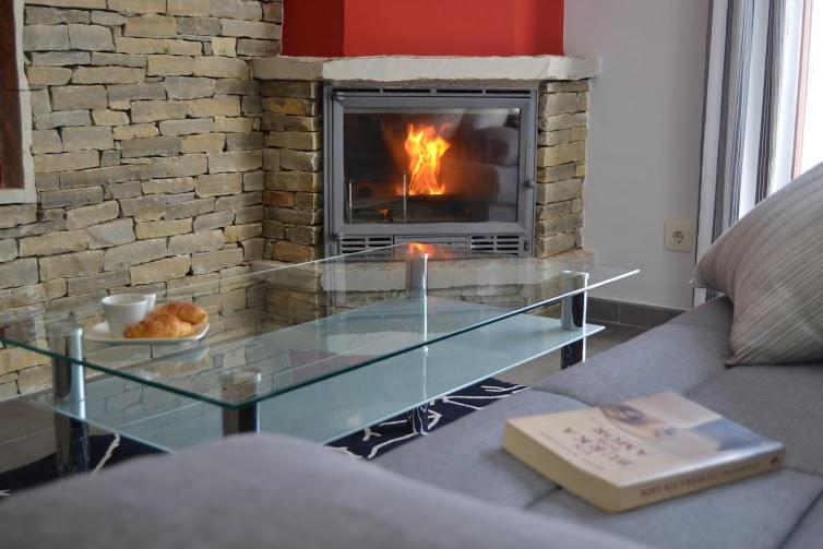 una mesa de centro de cristal en una sala de estar con chimenea en Casa Bielsa, en Mosqueruela