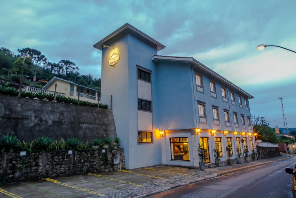 un bâtiment avec une horloge sur son côté dans l'établissement Pousada Il Villaggio, à Santo Antônio do Pinhal