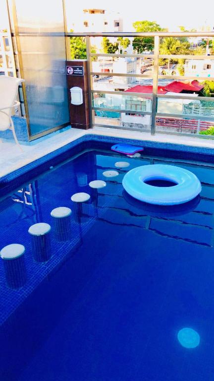 a swimming pool with a toilet and stools in it at Condo Mar Arena in Playa del Carmen