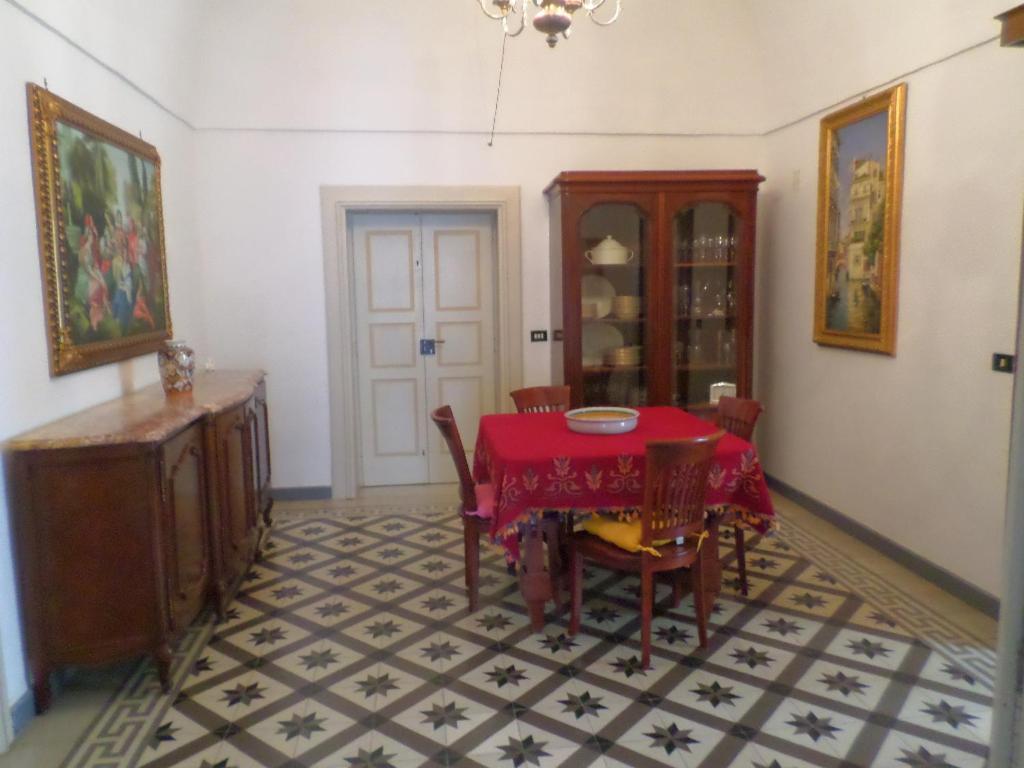 una sala da pranzo con tavolo e sedie rossi di Casa Millenovecento a Brindisi