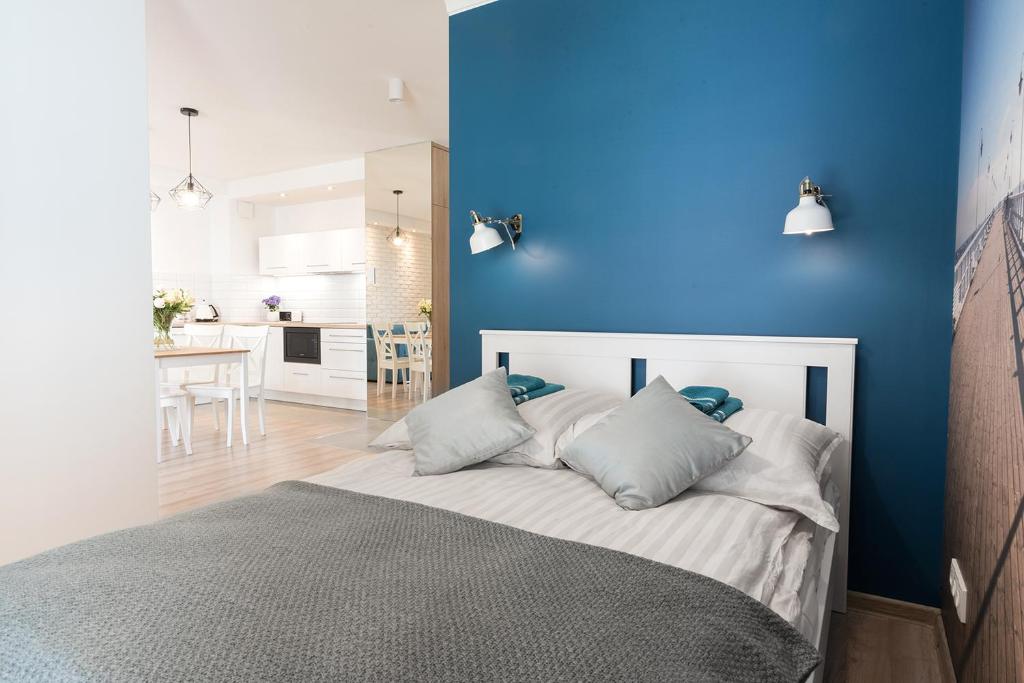 グディニャにあるBlue Apartment in vibrant heart of Gdyniaの青い壁のベッドルーム1室、ベッド1台(枕付)