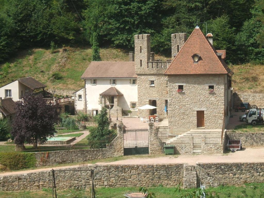 Saint-Sernin-du-Bois的住宿－Domaine Du Bas De Chene，一座大型石头建筑,山上有塔