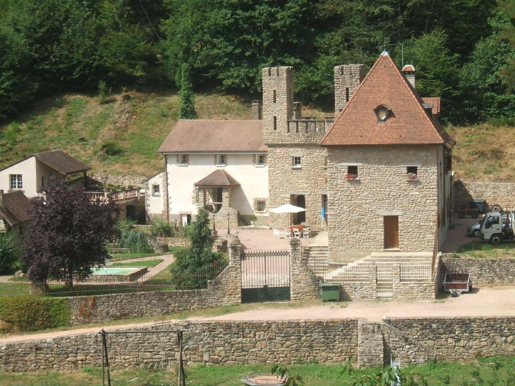 a large stone building with a tower on a hill at Domaine Du Bas De Chene in Saint-Sernin-du-Bois