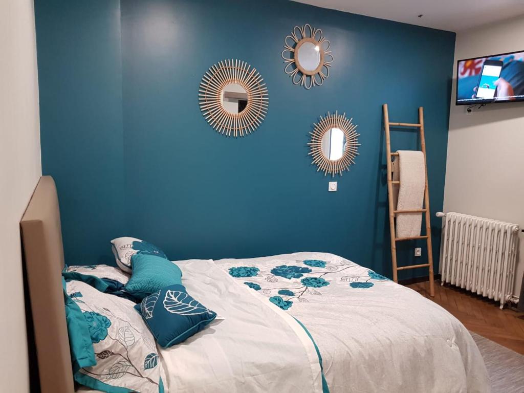 a blue bedroom with a bed and two mirrors at Hameau des Essarts in Grand-Couronne