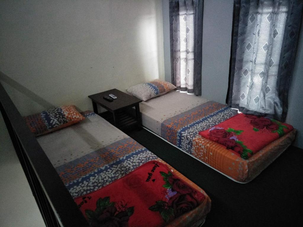 a bedroom with two beds and a window at Titan's Greenhouse in Banyuwangi