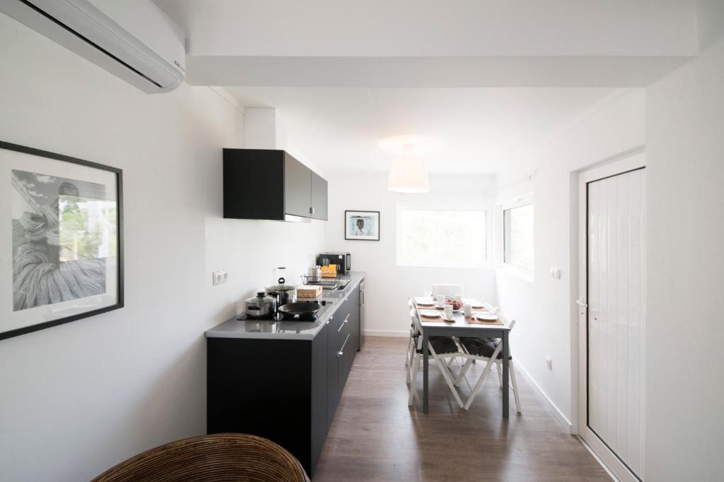 a kitchen with a black counter and a table at Quinta do Meco - Beach & Nature in Aldeia do Meco